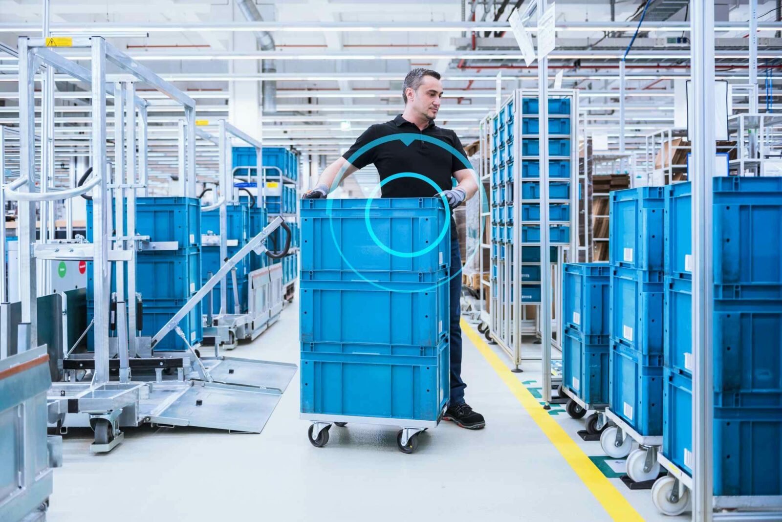 Employee moving blue containers in warehouse