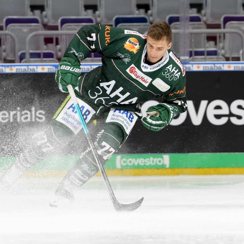 Eishockey Spieler in Bewegung mit Schläger und Puck