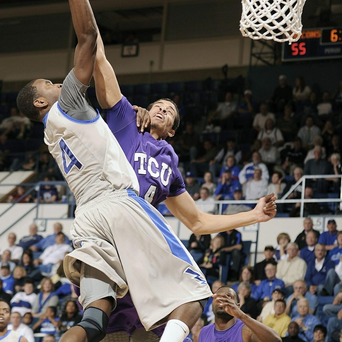 A basketball player blocks a shot after reviewing sports data to notice a pattern in the opposing team's offensive attack.