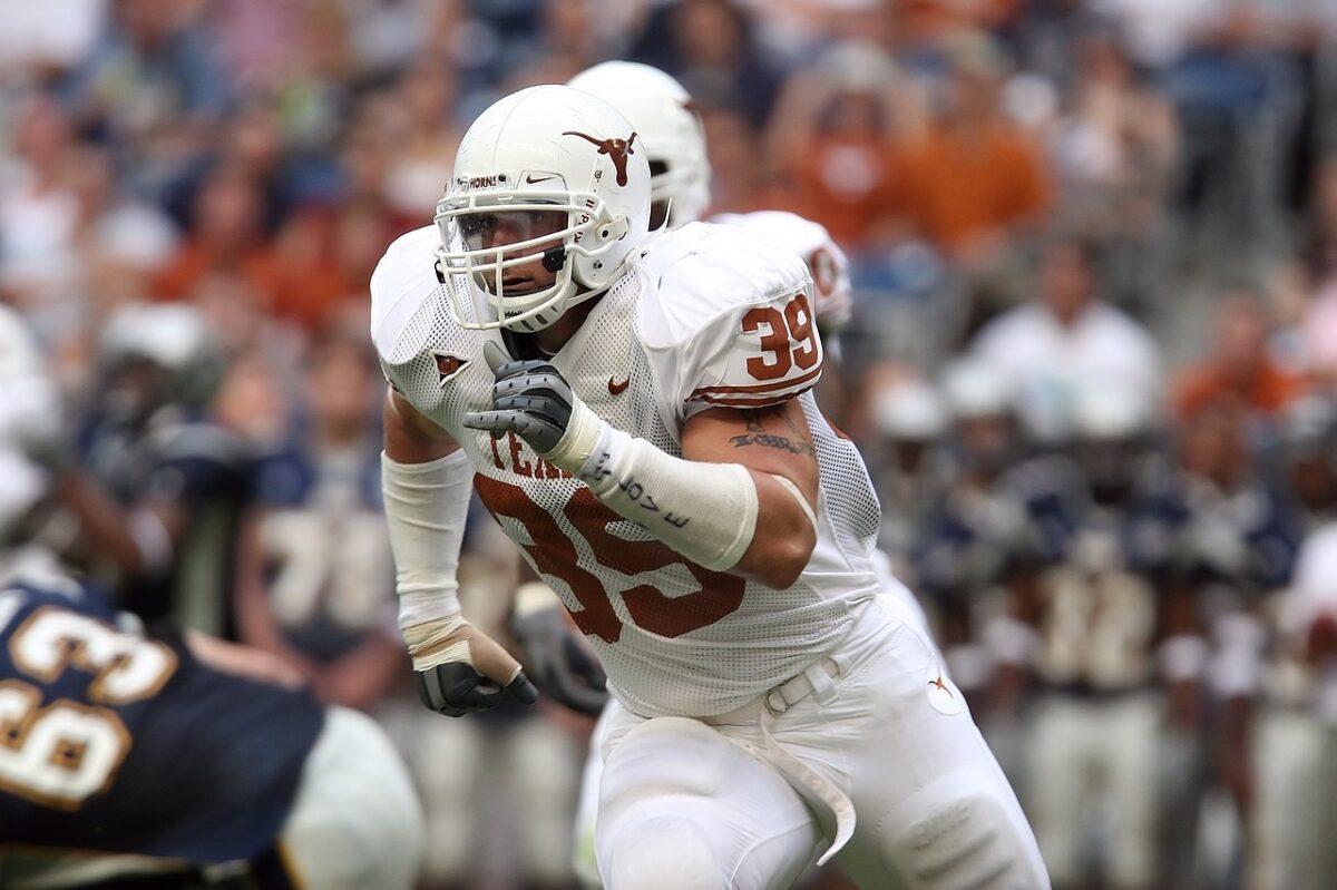 A football player runs after the quarterback to try to make a tackle.