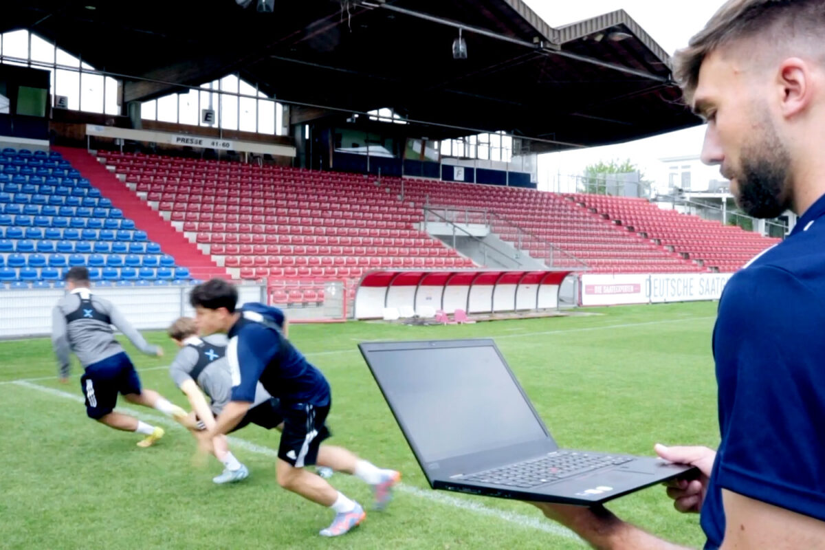 A coach pays attention to the data he is getting from a soccer GPS tracker that his players wear to help improve their performance.