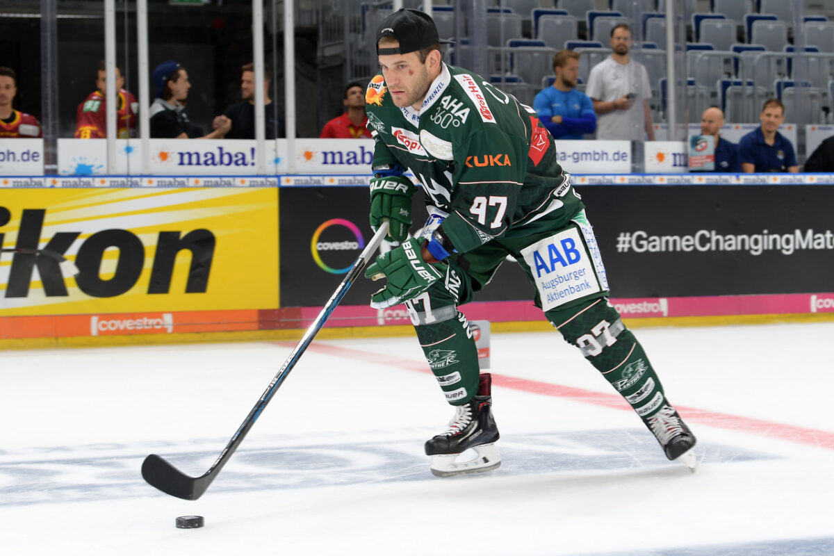 Hockey Player in green on ice with puck