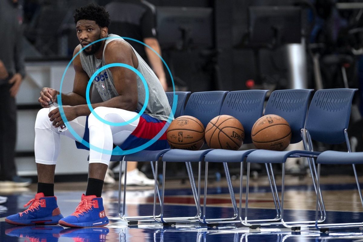 Basketball Player sits on bench beside balls
