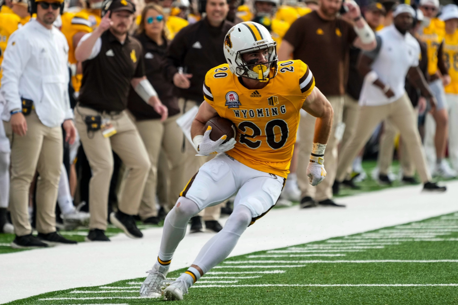 Ein Football-Spieler der University of Wyoming läuft während eines Spiels mit dem Ball, während er ein Spieler-Tracking-Gerät trägt, das Daten und Analysen sammelt.