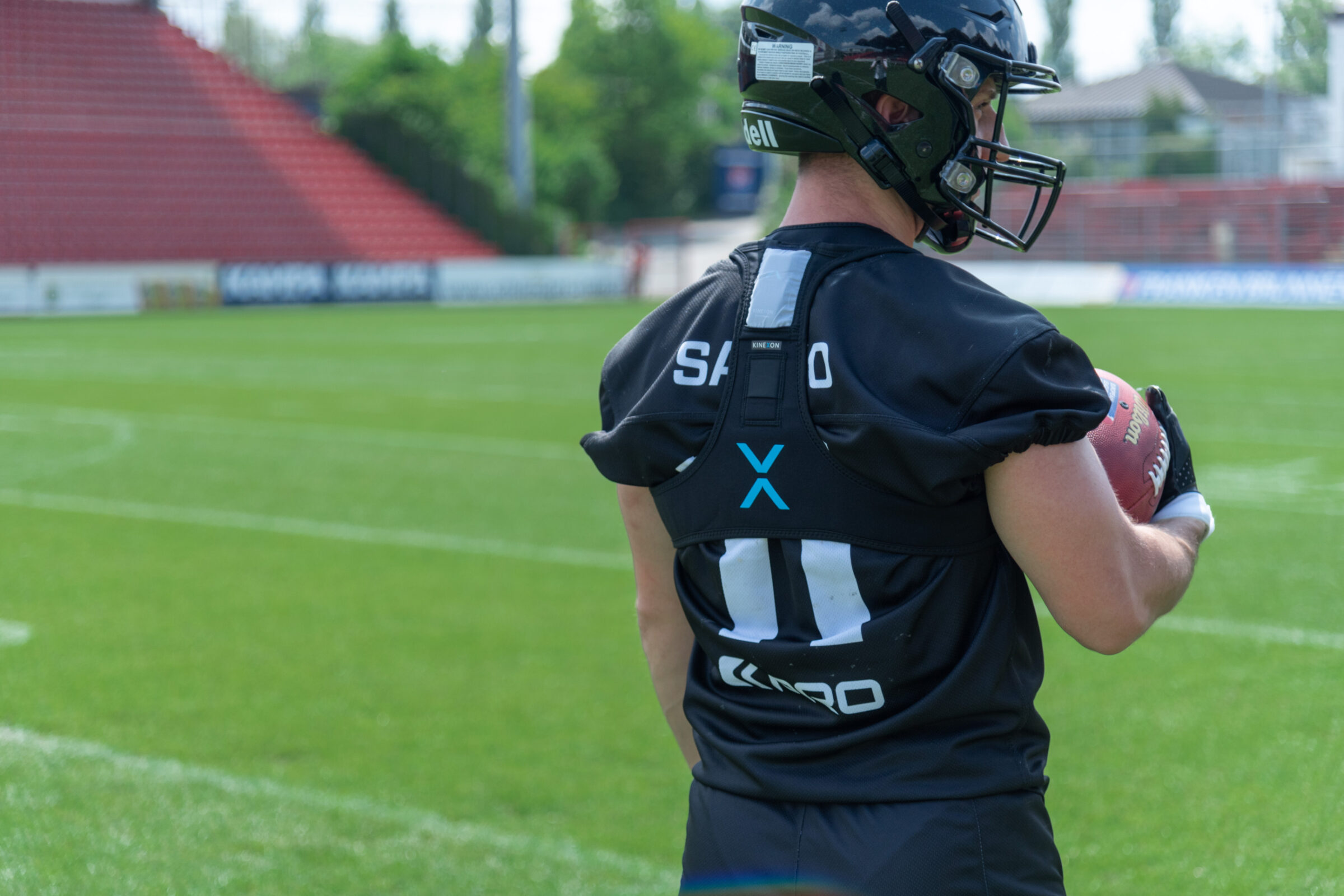 A football player wears a GPS player tracker that will monitor mechanical loading while he's taking part in practice or a game.