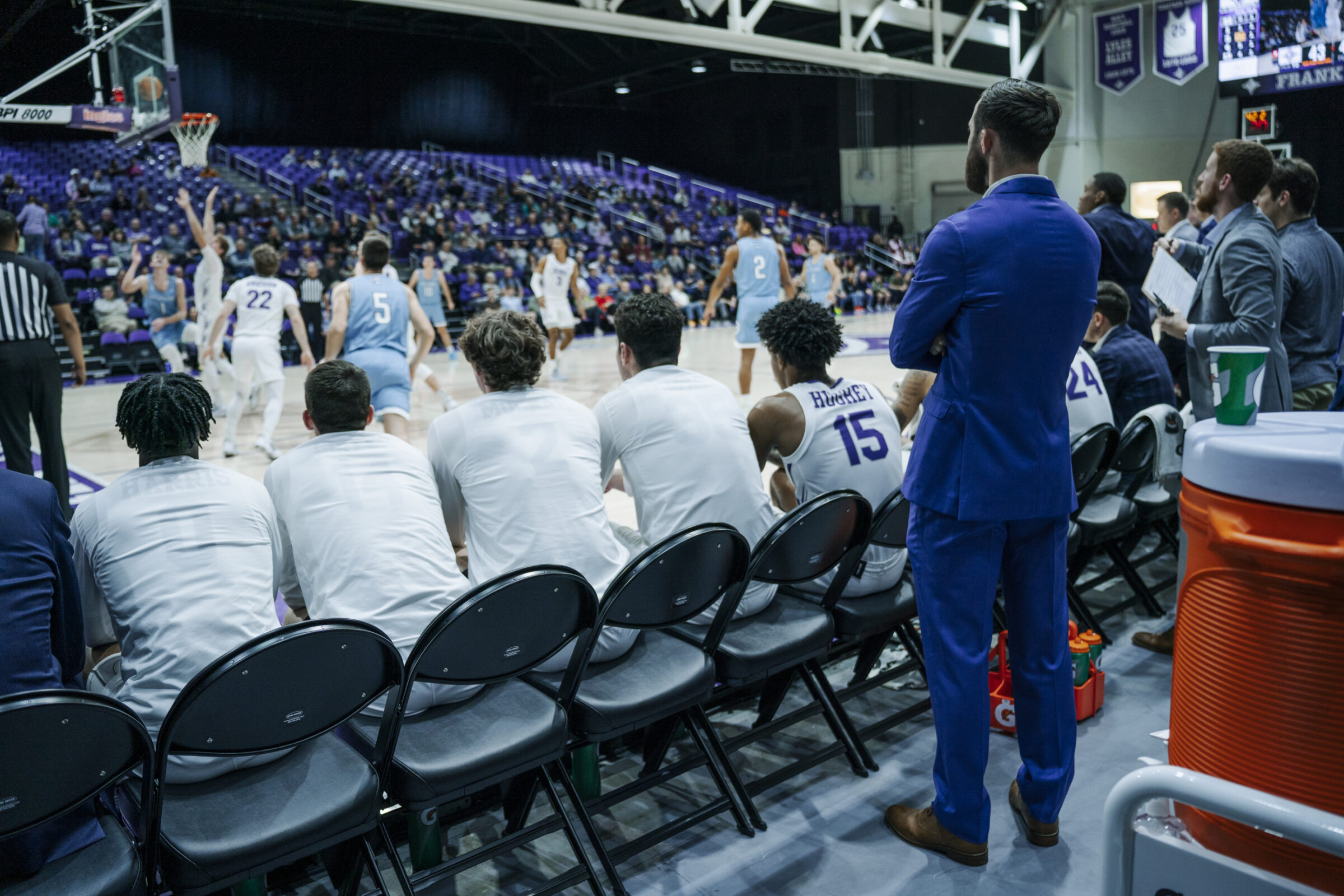 Players rest on the bench during a basketball game as part of their load management plan.