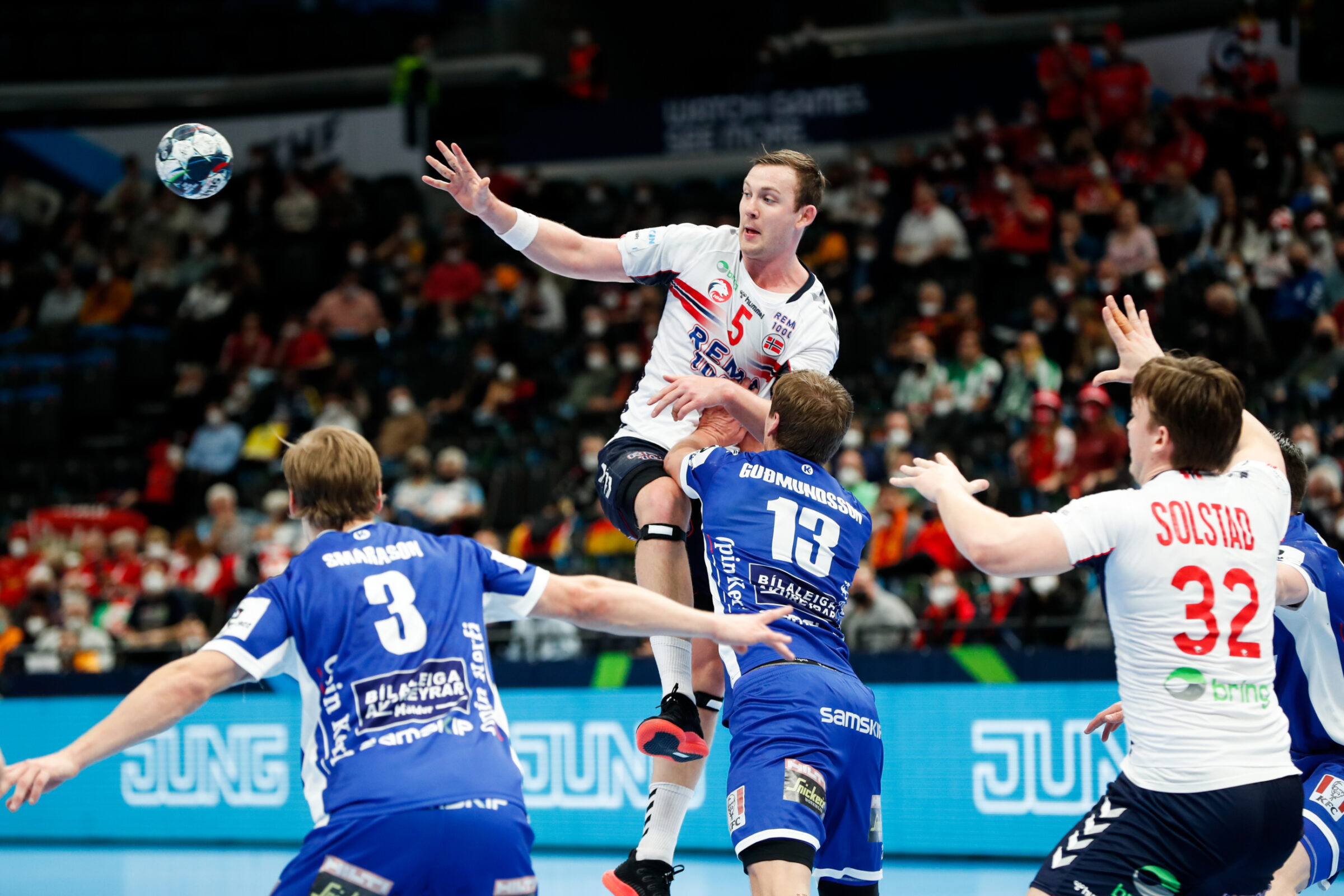 A team handball player leaps into the air to make a pass.