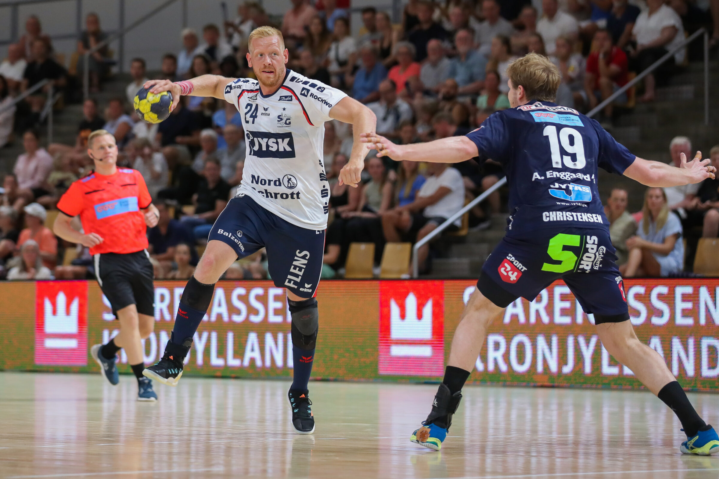 A professional team handball player attempts to take a shot while wearing a player tracking device that monitors his performance and his health.