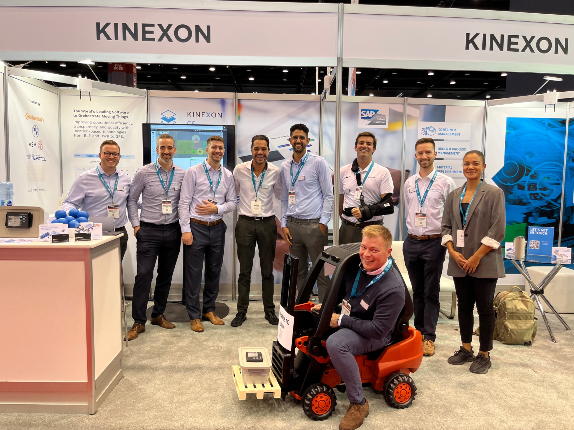 men and women in a group picture with man in a forklift