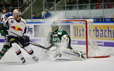 A hockey goalie makes a save with a defenseman guarding nearby. Coaches often use sports data to get players in the right position during a game.