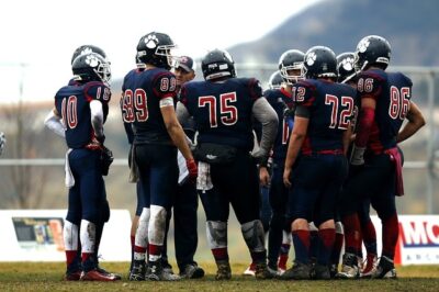 A football team huddles in the 4th quarter of a game, when coaches rely on sports performance analysis to help them make the right decisions.