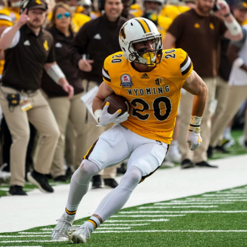 Ein Football-Spieler der University of Wyoming läuft während eines Spiels mit dem Ball, während er ein Spieler-Tracking-Gerät trägt, das Daten und Analysen sammelt.