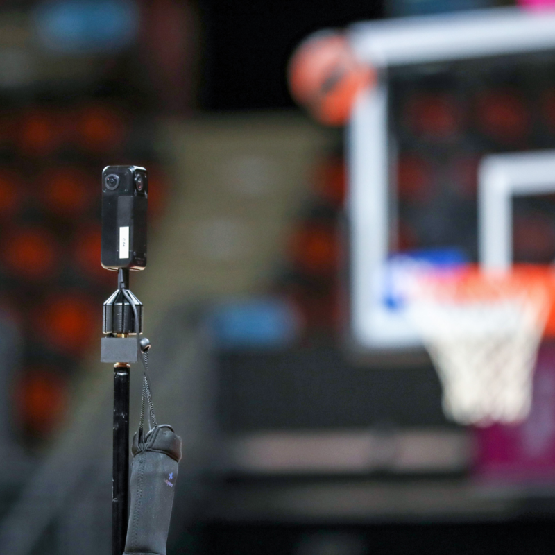 A video camera records a basketball practice so that the film can be uploaded into an app that will provide sports analytics for coaches and trainers to view.