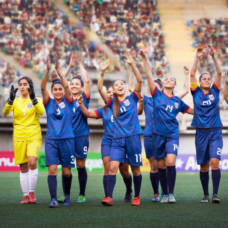 A group of women athletes celebrate a win.